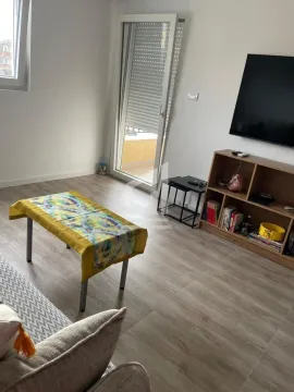Living room with a TV, shelving unit, and access to the terrace. - image 3