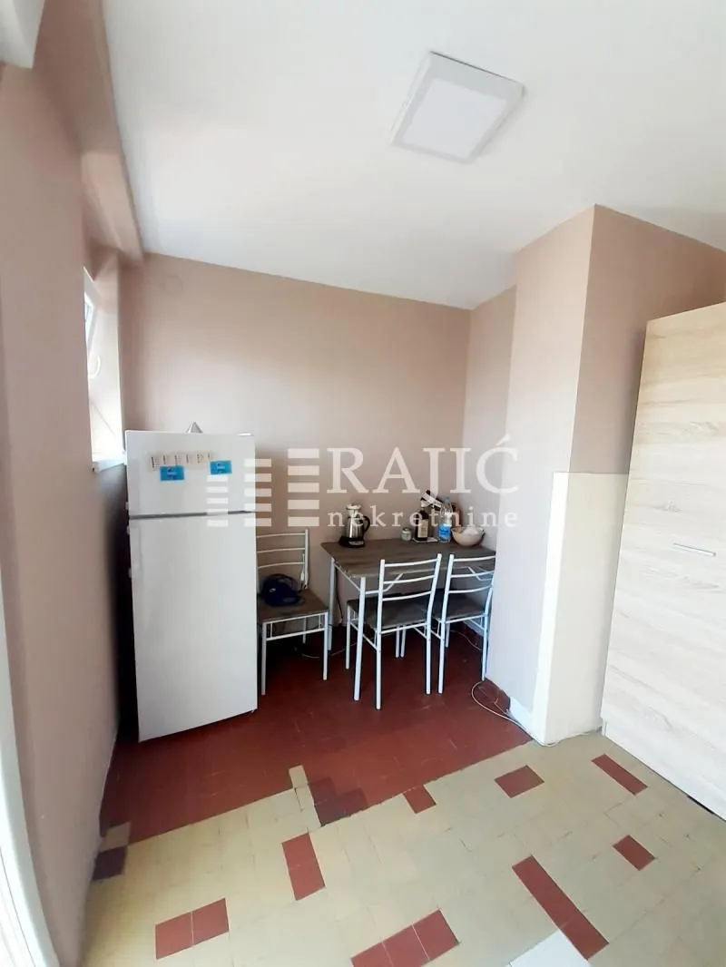 Smaller kitchen with a dining table and refrigerator.