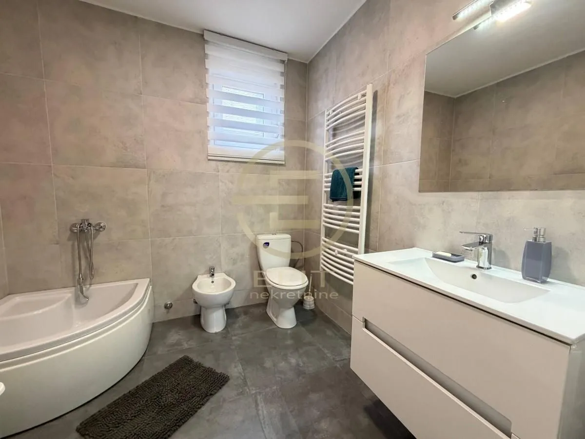 Moderno kupatilo sa kadom, umivaonikom i WC šoljom.