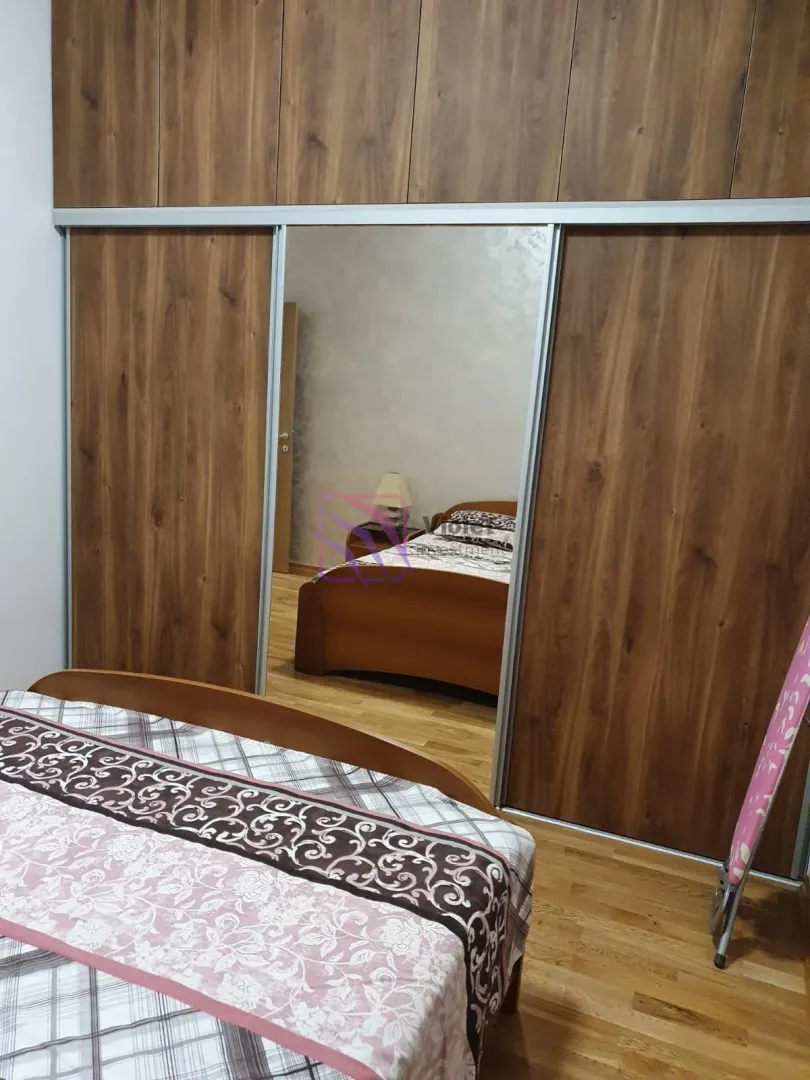 Bedroom with a large wooden wardrobe and mirror.