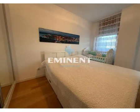 Nameštena spavaća soba sa bračnim krevetom, krevecem i prozorom. - image 7