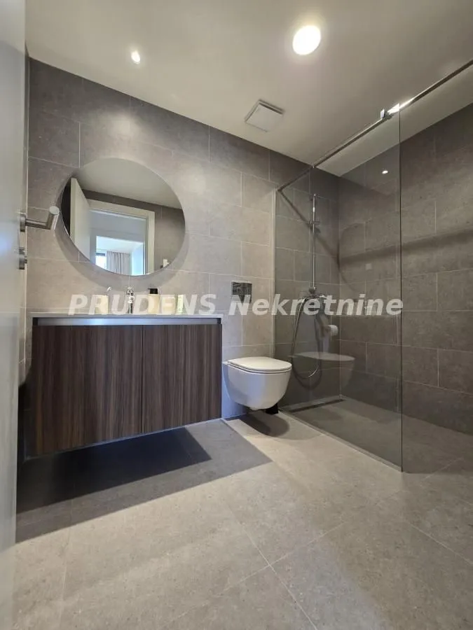 Moderno kupatilo sa tuš kabinom, umivaonikom i wc šoljom.