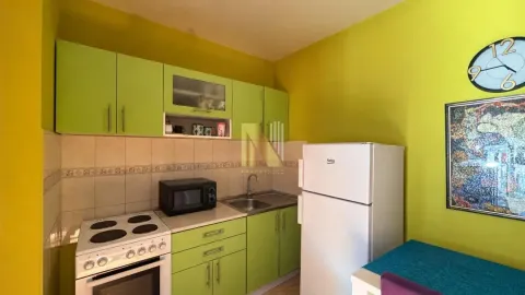 Manja kuhinja sa zelenim elementima, frižiderom i šporetom. - image 3