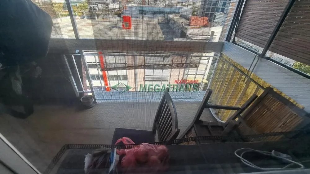 Natkriveni balkon sa pogledom na ulicu i okolne zgrade.
