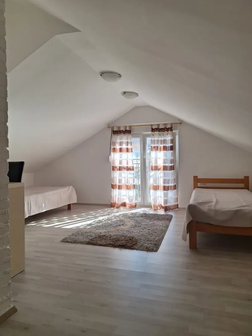 Attic bedroom furnished with two beds and access to a terrace.