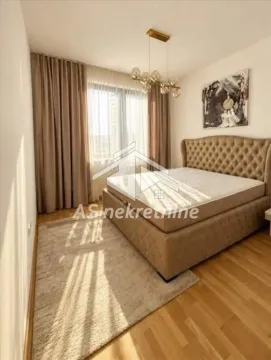 Spacious bedroom with a double bed, a large window, and a decorative chandelier. - image 7