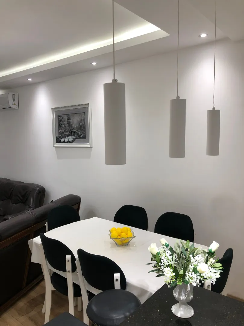 Dining area with a table, chairs, and pendant lights as part of the living room.