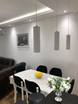 Dining area with a table, chairs, and pendant lights as part of the living room. - image 19