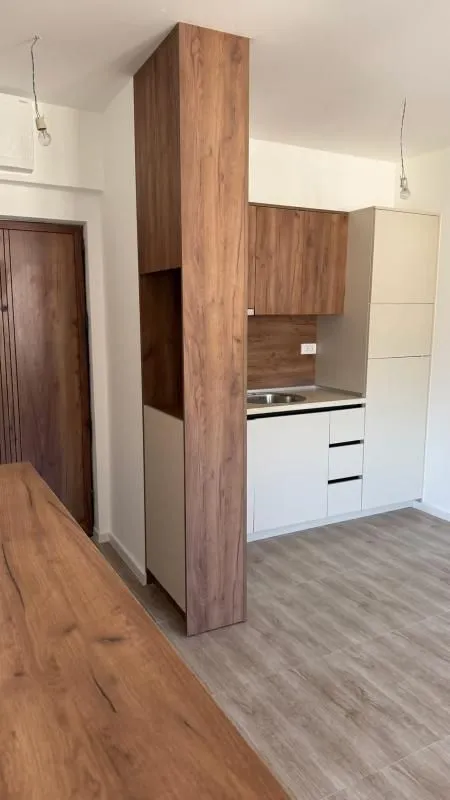 Manja kuhinja sa drvenim elementima u novom stanu.