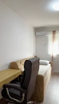 Smaller bedroom with a bed, desk, and air conditioning unit. - image 9