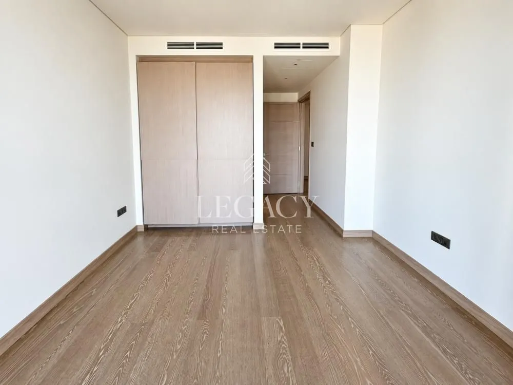 Prazna spavaća soba sa ugradnim ormanom i drvenim podom.