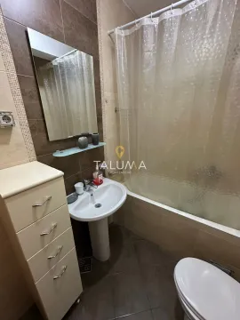 Bathroom equipped with a washbasin, mirror, bathtub, and toilet. - image 11