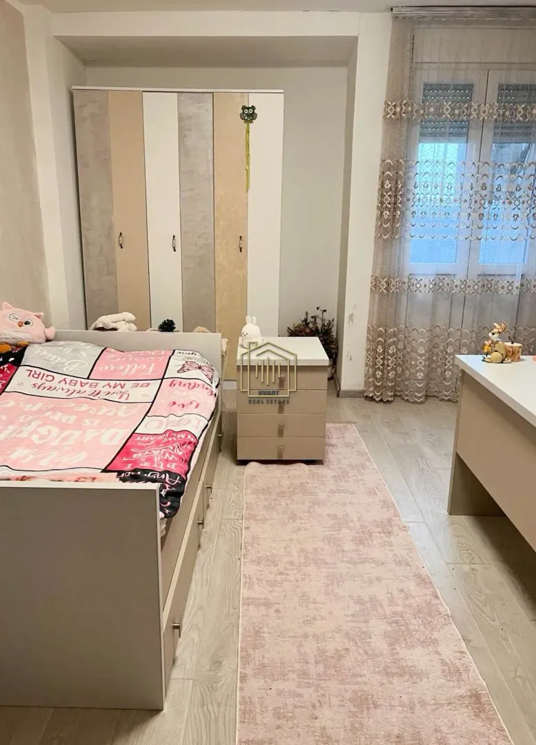 Dječja spavaća soba sa krevetom, plakarom i prozorom.