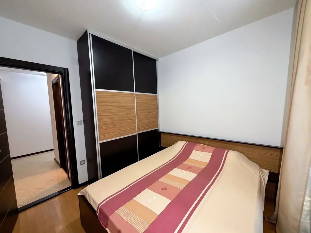 Furnished bedroom with a large wardrobe and a double bed.
