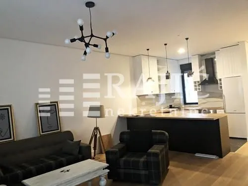 Modern living room with a sofa set and dining area in the background.