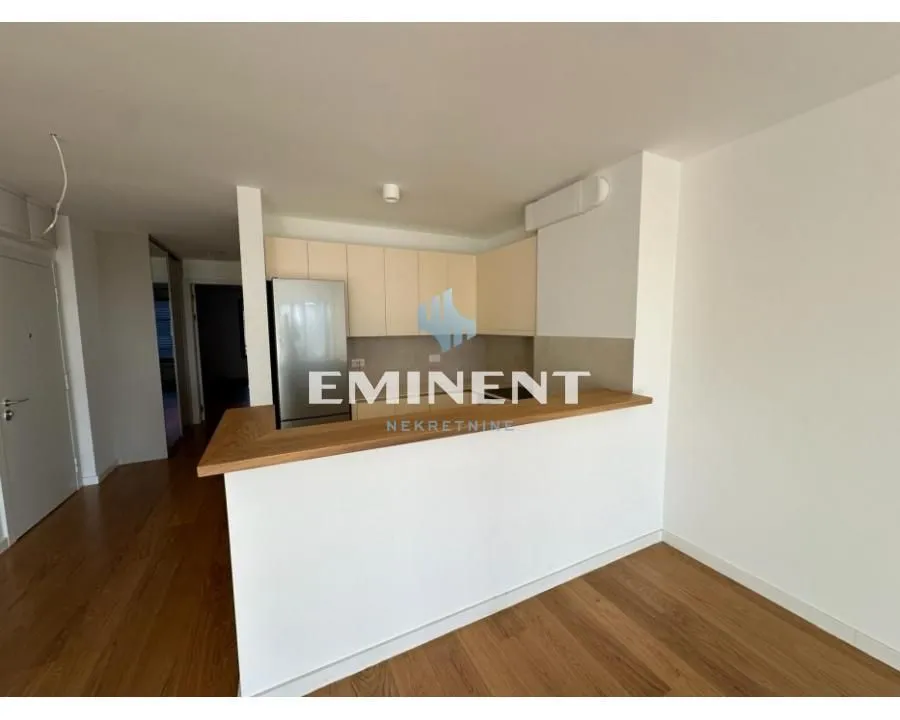 Small kitchen with a breakfast bar and wooden flooring in an apartment.