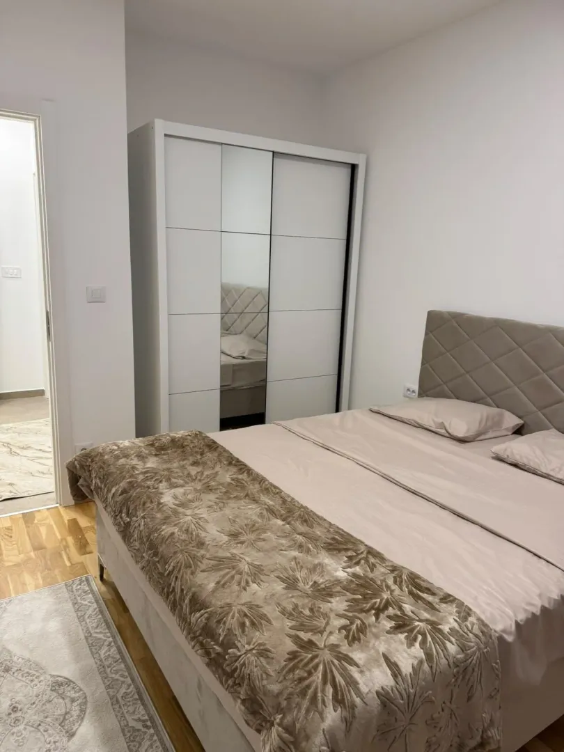 Furnished bedroom with a double bed and a wardrobe.