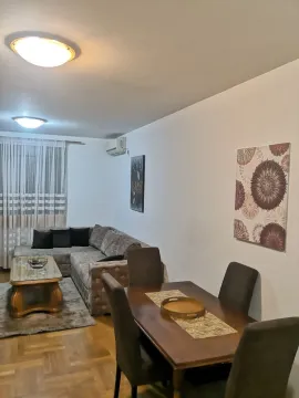 Svijetla dnevna soba sa trpezarijskim stolom i udobnom ugaonom garniturom. - image 2