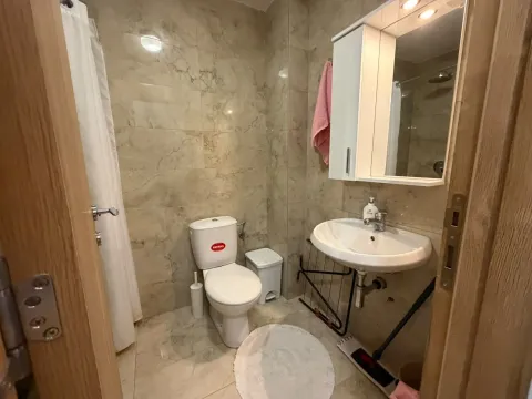 Manje kupatilo sa umivaonikom, WC šoljom i ogledalom sa ormarićem. - image 10