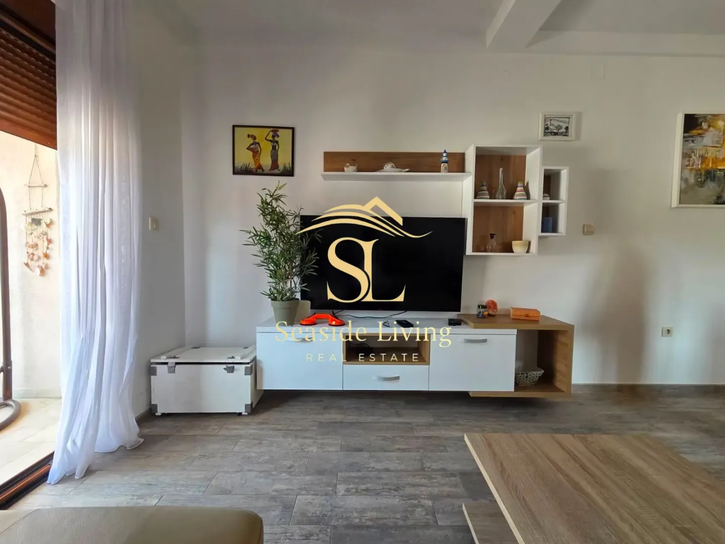 Dnevna soba sa televizorom i modernim namještajem.