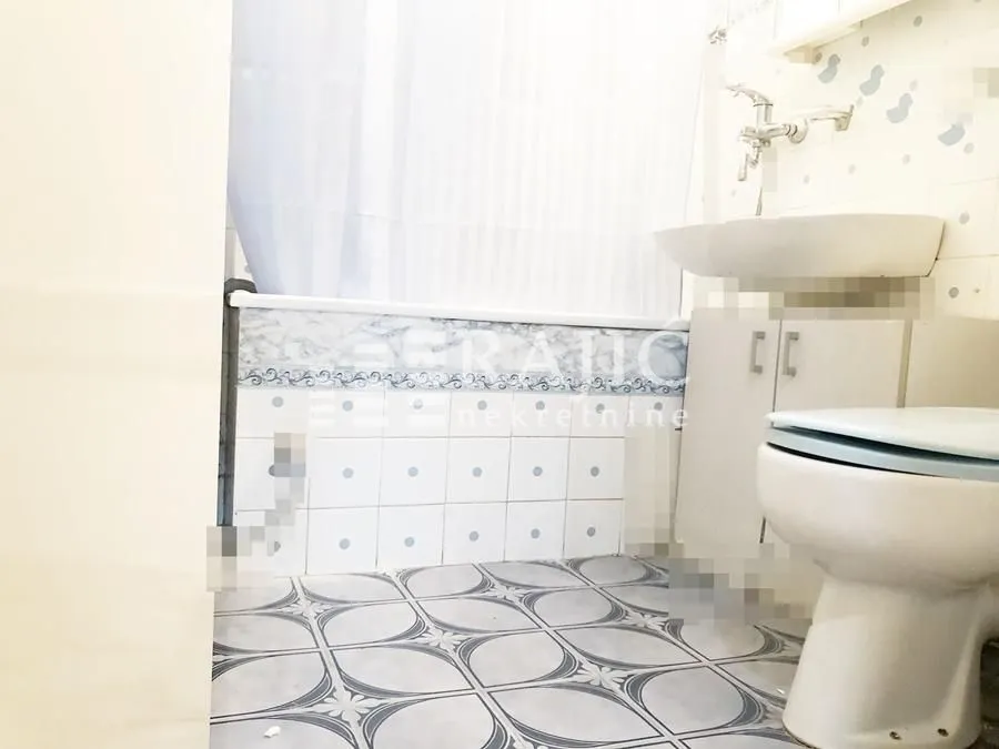 Smaller bathroom with a bathtub, washbasin, and toilet.