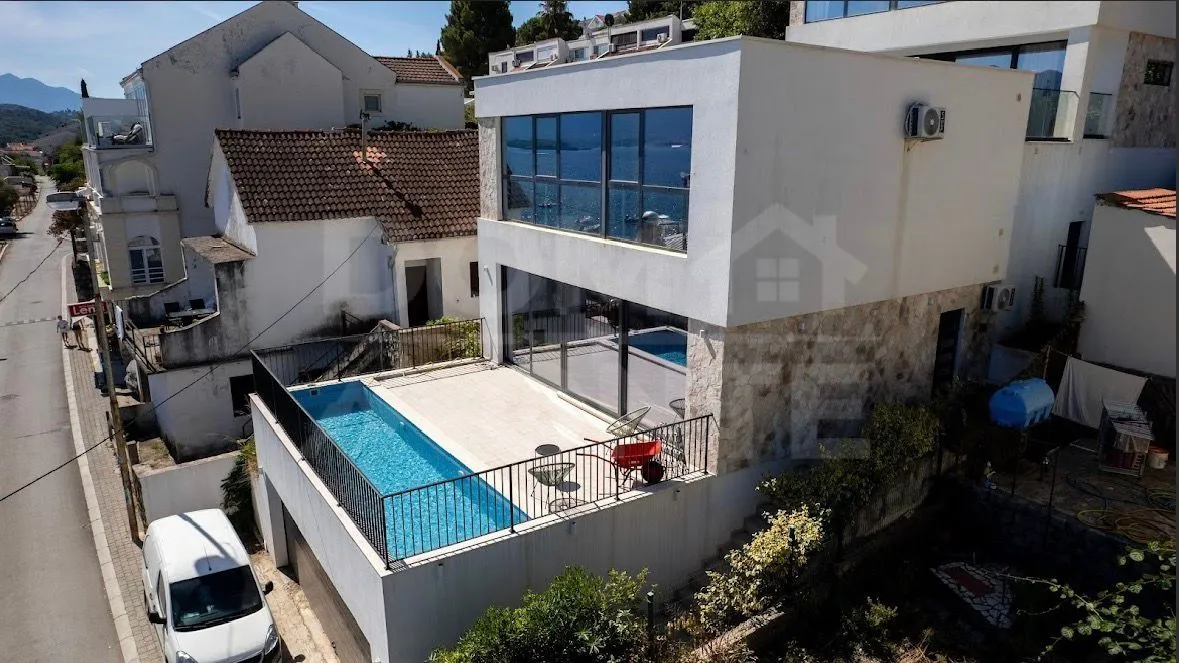 Exterior of a modern house with a swimming pool and sea view.