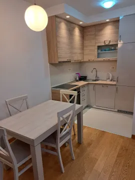 Moderna kuhinja sa trpezarijskim stolom i drvenim elementima. - image 2