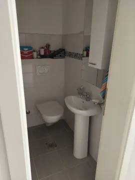 Small bathroom with a pedestal sink and toilet. - image 18