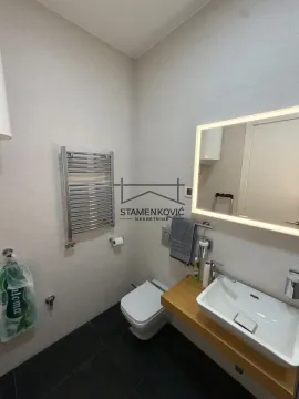 Savremeno opremljeno kupatilo sa umivaonikom, WC šoljom i ogledalom sa pozadinskim osvetljenjem. - image 8