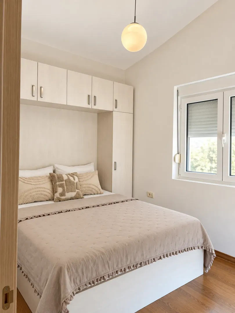 A furnished bedroom with a double bed and built-in closets.