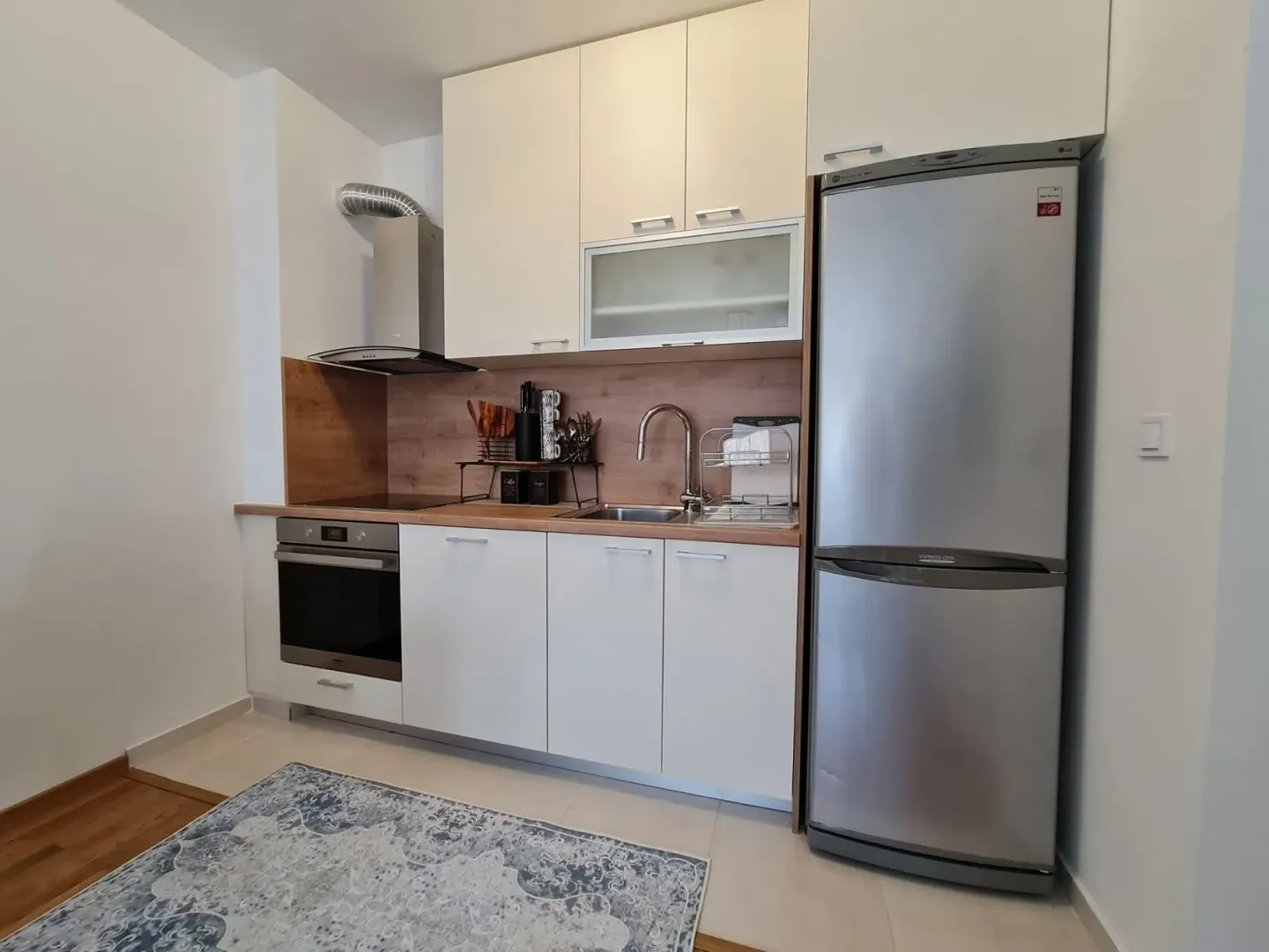 Modern kitchen featuring white cabinets and a stainless steel refrigerator.