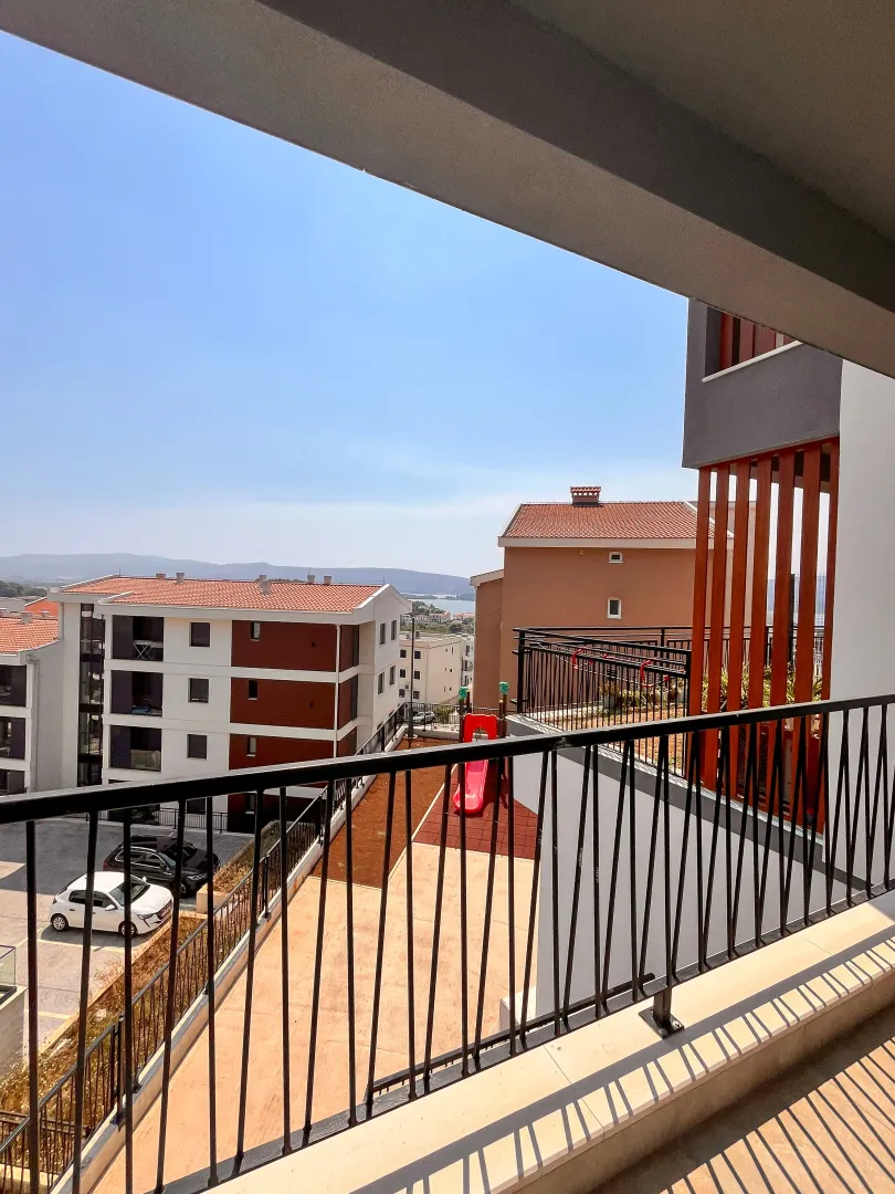 Pogled sa terase na zgrade i dvorište sa igralištem.