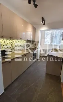 Modern kitchen with beige cabinets and built-in appliances. - image 6