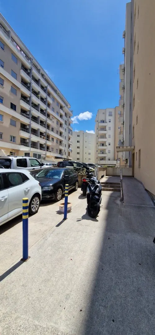 Eksterijer stambene zgrade sa parkingom i prilazom.