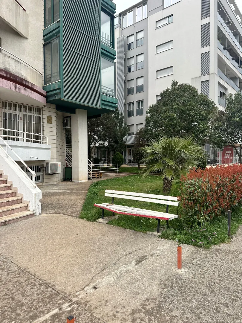 Yard with a bench in front of the residential building.