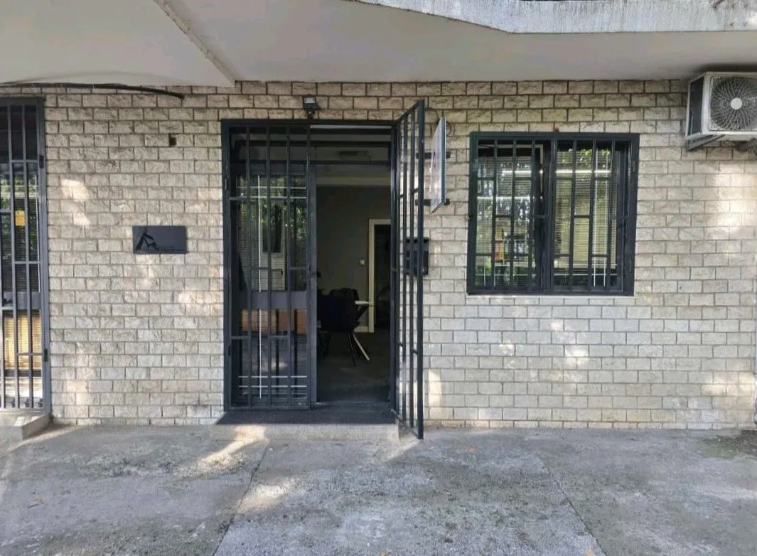 Entrance to a commercial space with a stone facade and security bars.
