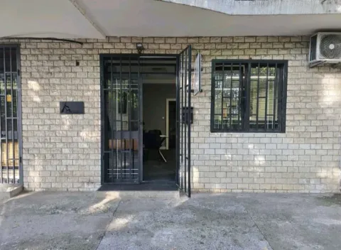 Entrance to a commercial space with a stone facade and security bars. - image 3