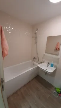 Kupatilo sa bijelim pločicama, kadom i lavaboom. - image 9