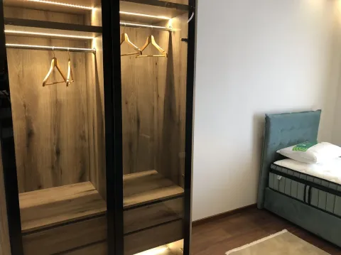 Bright bedroom with a modern built-in wardrobe and a bed. - image 25