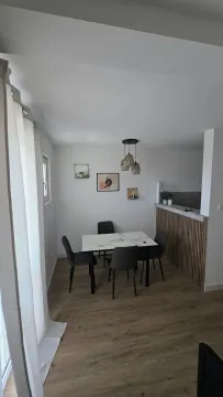 Dining area with a table and chairs and a view of part of the kitchen. - image 13