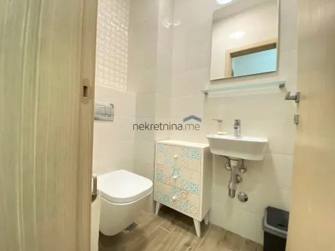 Small modern bathroom with white tiles, washbasin, toilet, and mirror. - image 6
