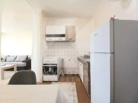 Manja kuhinja sa bijelim i drvenim elementima, šporetom i frižiderom. - image 3