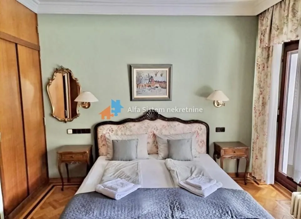 Furnished bedroom with a double bed, nightstands, and a built-in wardrobe.