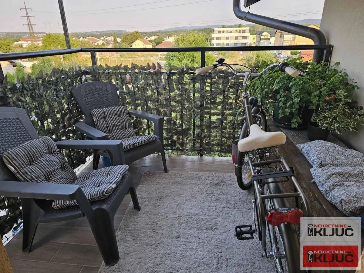 Namešten balkon sa garniturom za sedenje i biciklom.