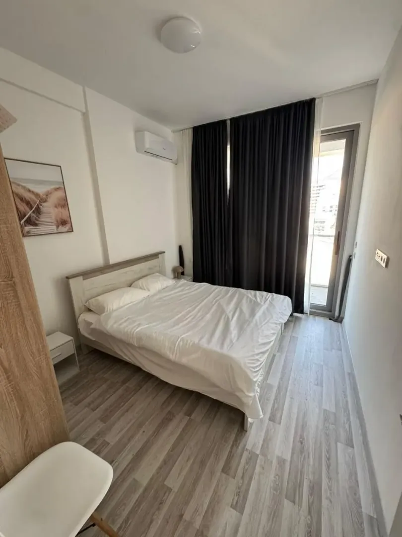 Spavaća soba sa bračnim krevetom, klima uređajem i izlazom na terasu.