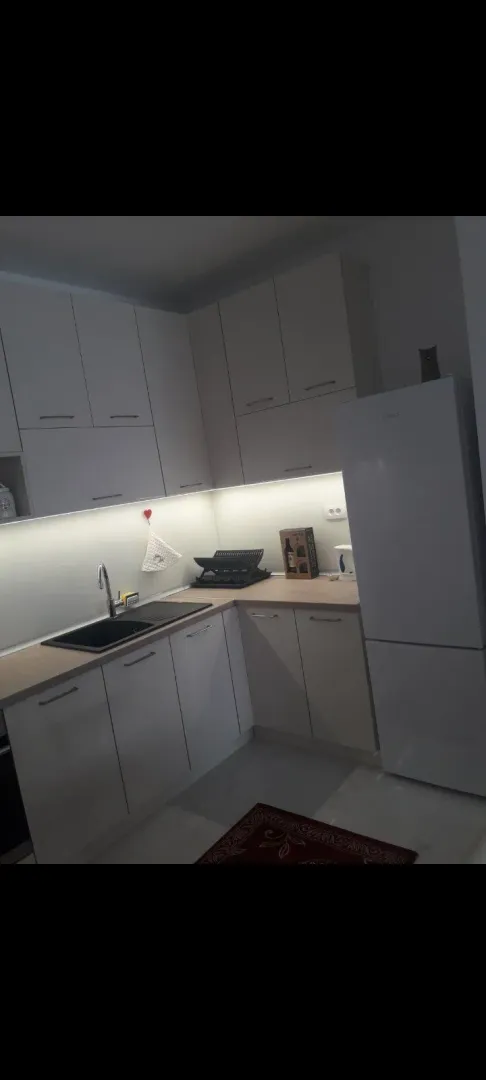 Bright kitchen with white cabinets and under-cabinet lighting.