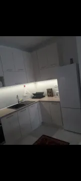 Bright kitchen with white cabinets and under-cabinet lighting. - image 14