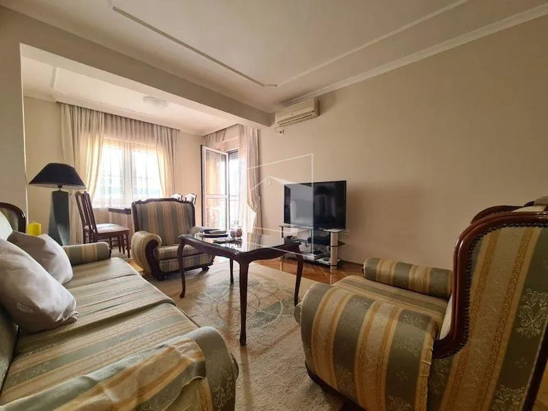 Living room with sofa set, coffee table, and television.