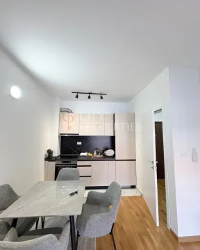 Small kitchen connected to the dining area with a modern dining table. - image 6