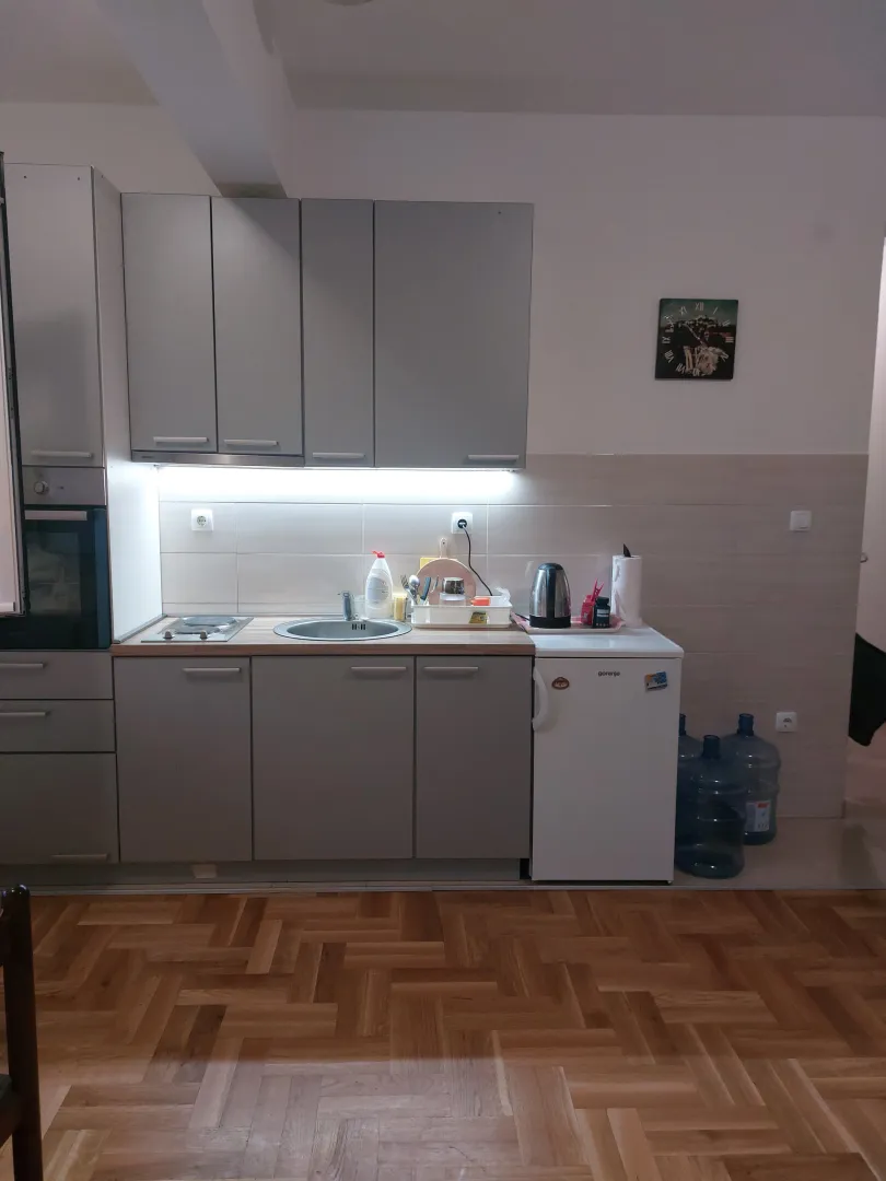 Small kitchen with grey cabinets and parquet flooring.